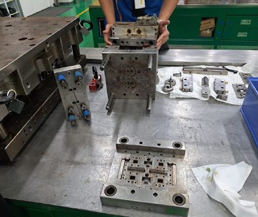 Mould disassembled for maintenance on a toolroom bench